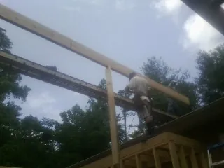 Carpenter setting a ridge beam over a new addition frame — Ice Dam Removal by Roofing Brothers in Albright