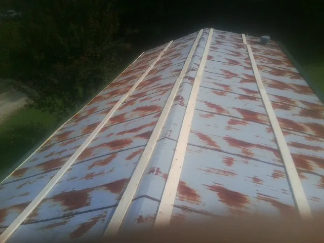 Rusted metal roof panels with new wood purlins before replacement — Storm Damage Roof Repair in Albright by Roofing Brothers