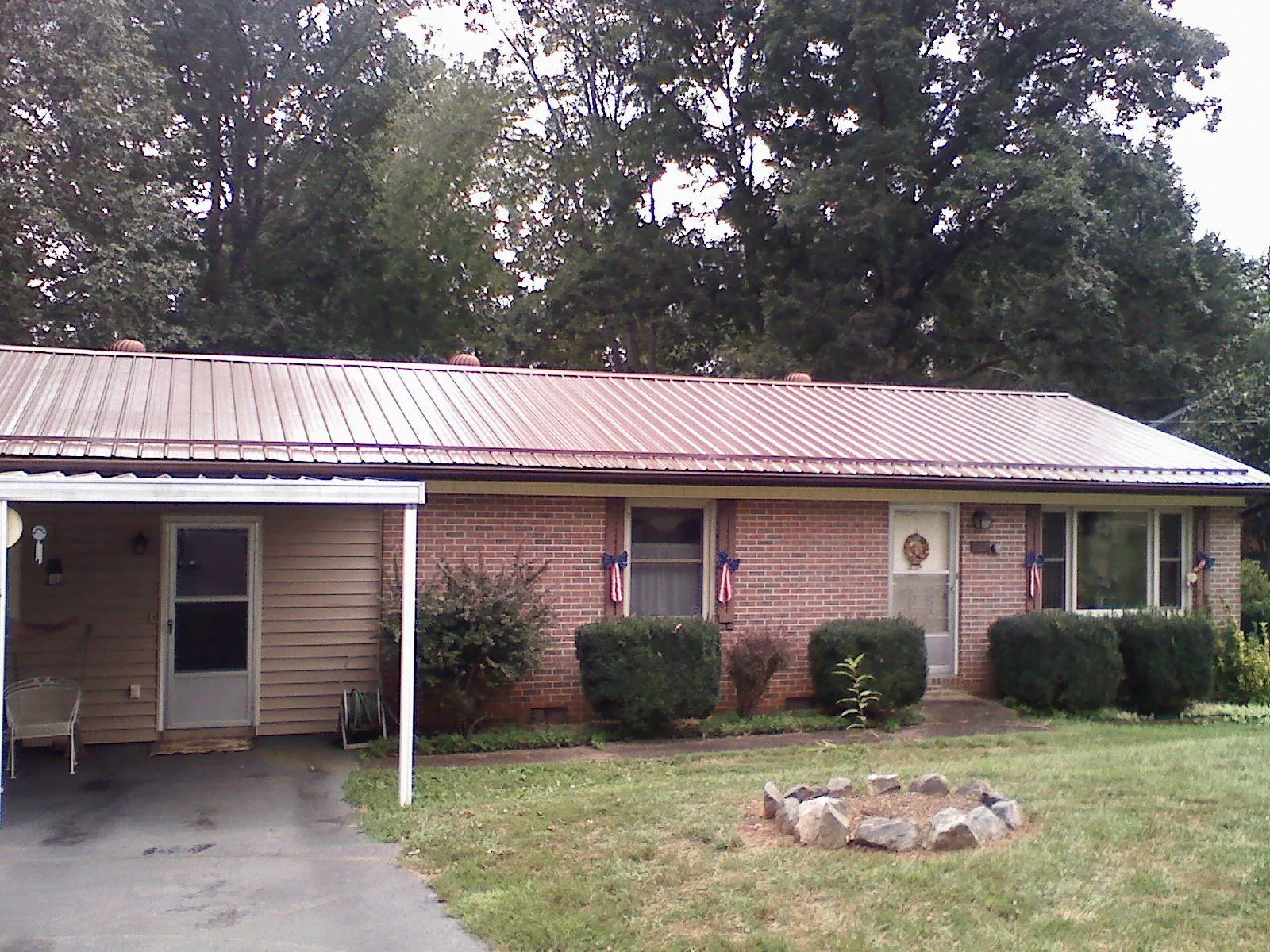 Bronze metal roof and carport on a brick ranch home — Roof Repair work by our crew in Albright